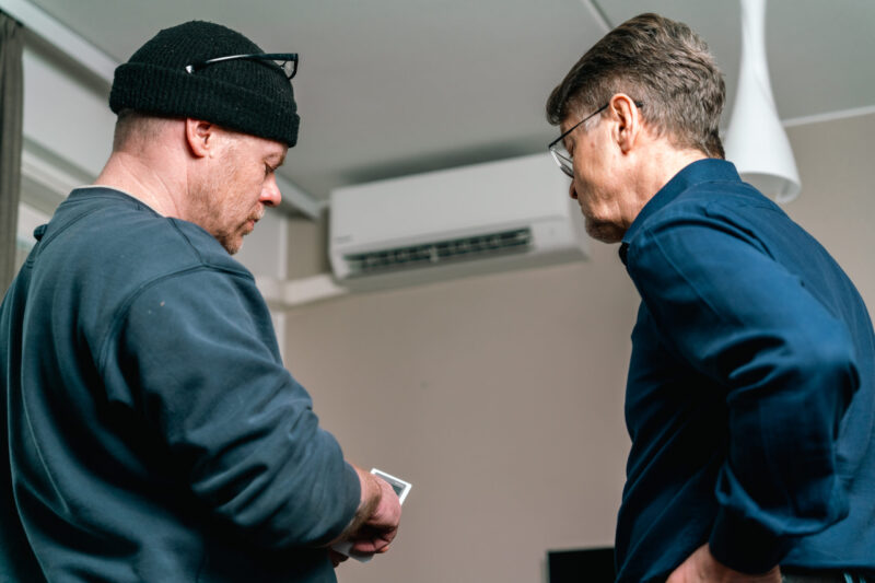 Asentaja ohjeistaa asiakasta ilmalämpöpumpun käytöstä