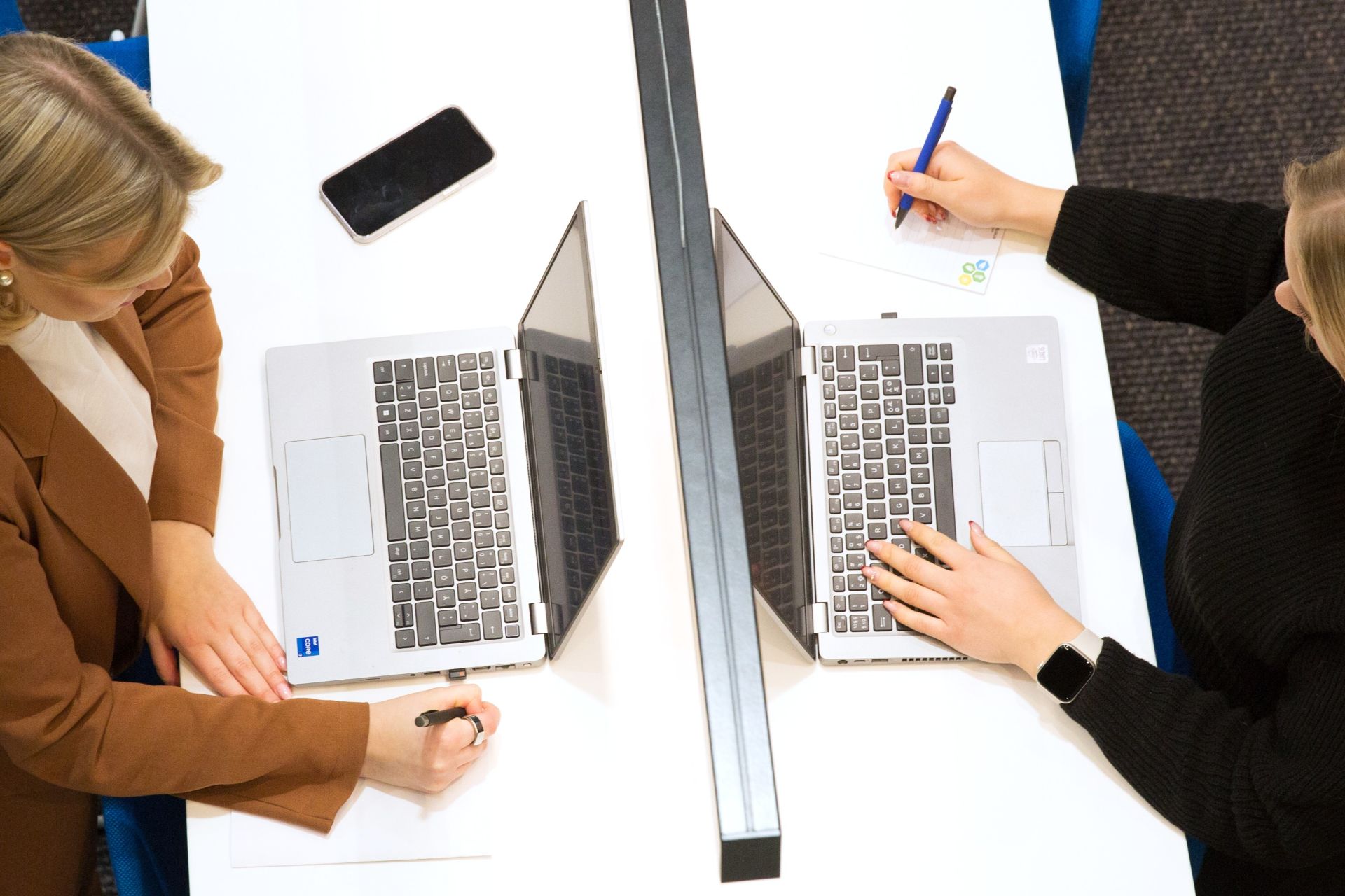 Kaksi naista palaverissa töissä.