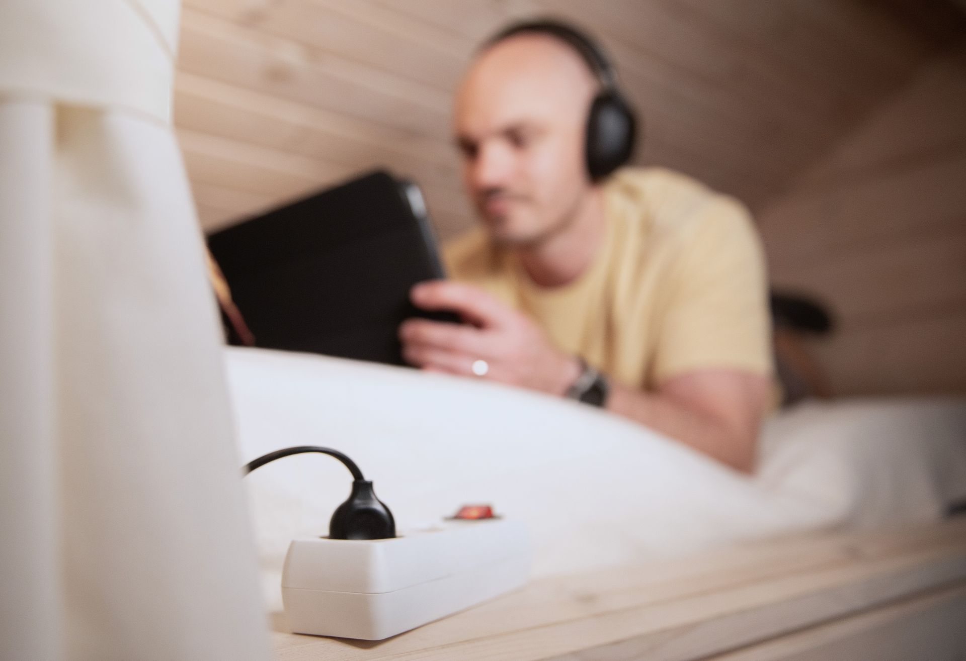 Tietokone latauksessa sängyllä