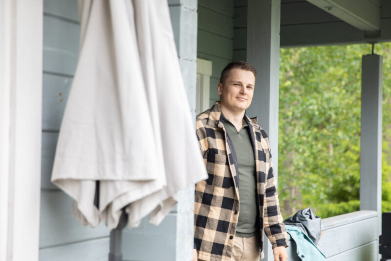 Mies seisoo mökin kuistilla