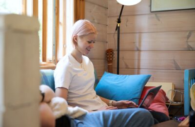 Nainen on tietokoneen ääressä olohuoneessa.